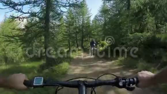 男子骑电子自行车跟随朋友女人mtb行动骑自行车者一起探索森林附近的小径电气视频的预览图