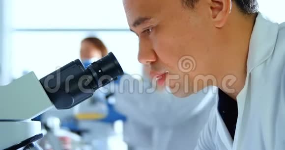 4k实验室使用显微镜的男科学家视频的预览图