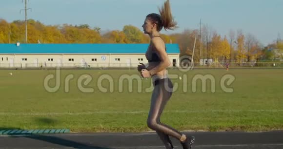 阳光明媚的一天女人在体育场跑步视频的预览图