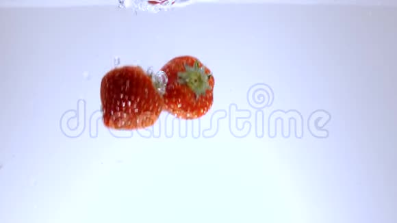 新鲜草莓落入水中慢镜头视频的预览图