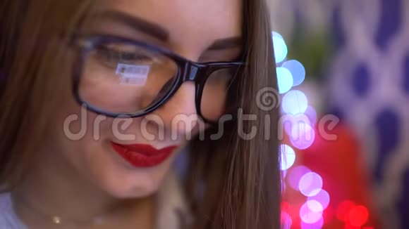 眼镜中女性眼睛的特写镜头反映了一个工作的平板电脑屏幕年轻女子使用平板电脑视频的预览图