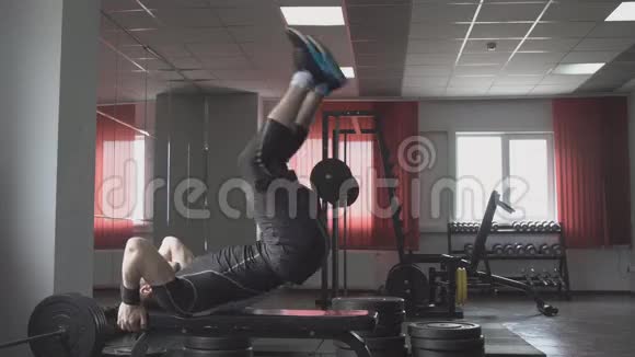 健身男子躺在长凳上抬起腿核心交叉训练锻炼腹肌视频的预览图