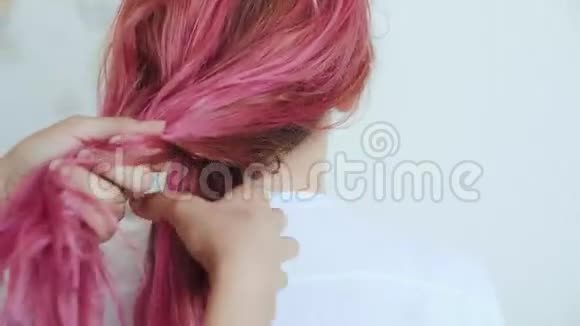 朋友给粉红头发的女孩做辫子视频的预览图