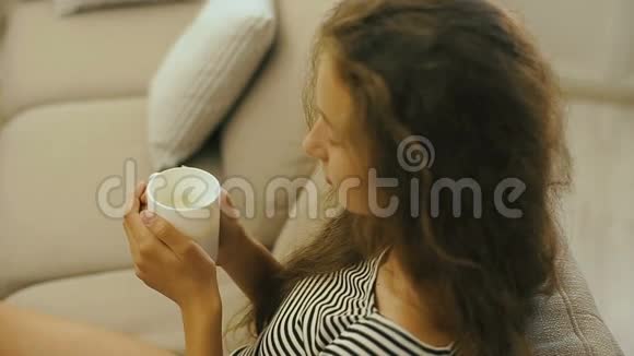 坐在沙发上喝着新鲜牛奶的小女孩视频的预览图