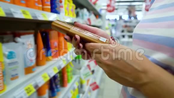 靠近商店货架的白种人女士选择市场上的化妆品视频的预览图