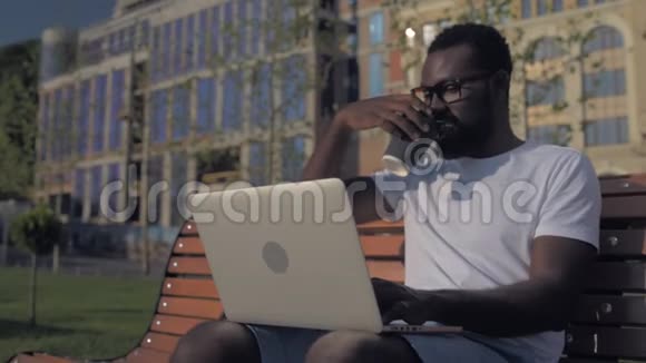 性格开朗的非裔美国人在工作时喝咖啡视频的预览图