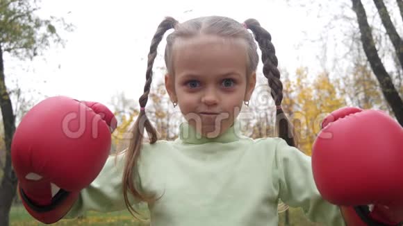 小女孩踢拳击手套做滑稽的傻脸视频的预览图