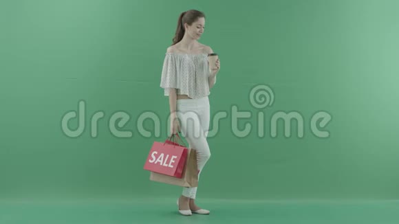 迷人的年轻女子茶咖啡把袋子放在绿色的屏幕上视频的预览图