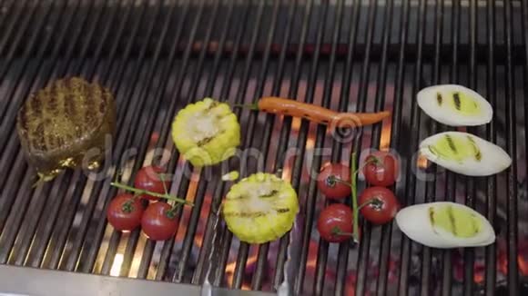 厨师在餐厅厨房的烤架上做蔬菜特写烤肉玉米樱桃西红柿视频的预览图