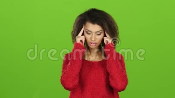 女人双手抱着太阳穴的头感到疼痛绿色屏幕视频的预览图