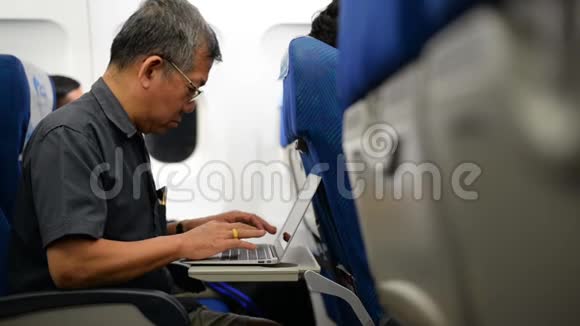 使用笔记本电脑飞行的亚裔老人视频的预览图