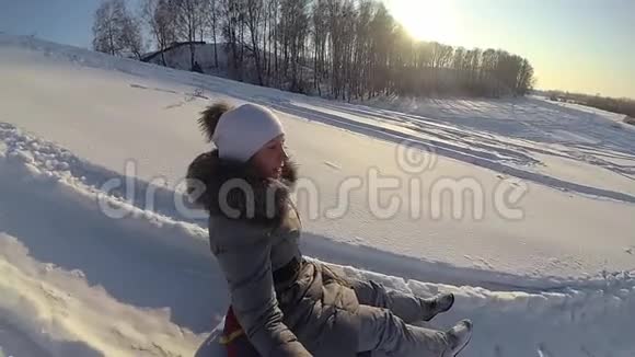 快乐的女孩骑在一座雪山上慢动作雪的冬季景观户外运动视频的预览图