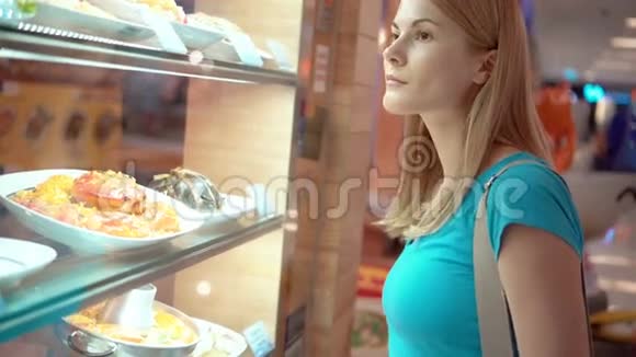 年轻美丽迷人的女人看着橱窗里的海鲜咖啡馆选择晚餐视频的预览图