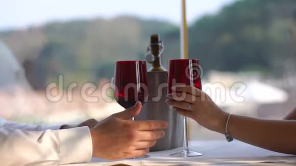有爱的夫妇正在进行浪漫的约会他们温柔地握着酒杯背景的手没有脸视频的预览图