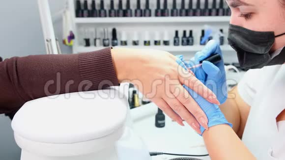 医生正在美容院给顾客的指甲美容院给客户的指甲涂上凝胶抛光剂竖起钉子假人视频的预览图