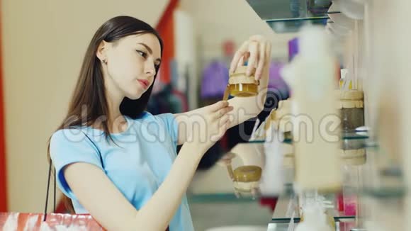 年轻女子在香水部门挑选物品打电话视频的预览图