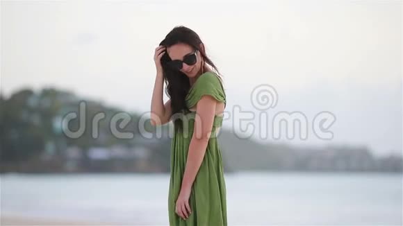 热带海滨的年轻美女海滩上一个穿绿衣的旅游女孩视频的预览图