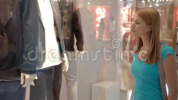 年轻迷人的女人看着商店的橱窗商场购物销售时间消费主义概念视频的预览图