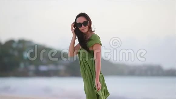 热带海滨的年轻美女海滩上一个穿绿衣的旅游女孩视频的预览图