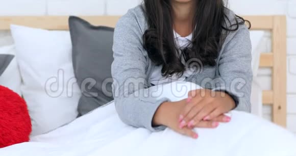 一个爱睡懒觉的年轻可爱的女孩头发乱糟糟躺在床上视频的预览图