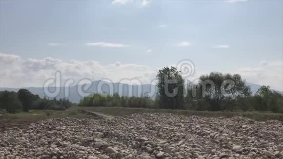 出口到一条山河的岩石海岸水流湍急地平线上有一条山链视频的预览图