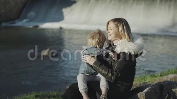 妈妈和儿子接吻可爱的特写镜头年轻的母亲带着她的小儿子在公园里放松和玩耍两者都是视频的预览图