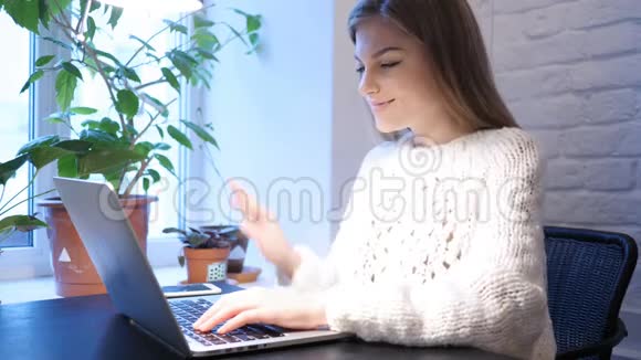 坐在办公室的年轻女性在笔记本电脑上进行网络视频聊天视频的预览图