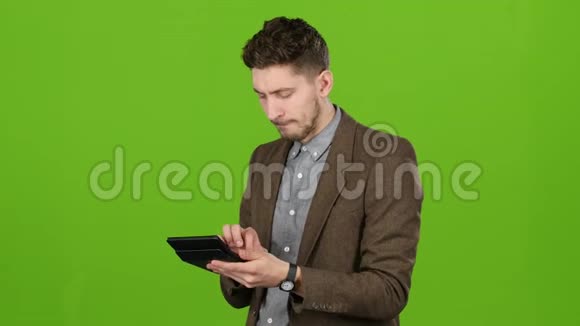商人把钱放在计算器上很高兴他有收入绿色屏幕视频的预览图