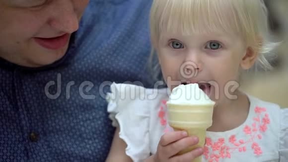 那个金发女孩有趣可爱的小女孩在大购物中心吃冰淇淋和喇叭一家人吃冰淇淋视频的预览图