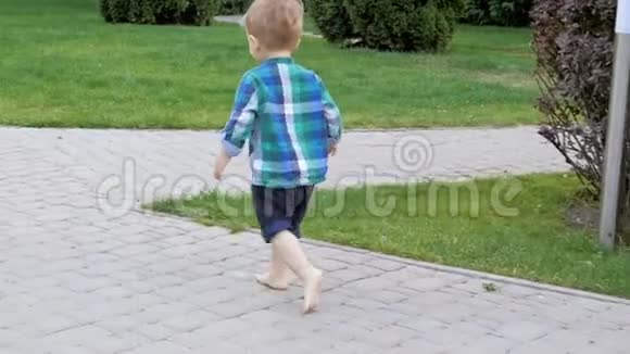 可爱的赤脚幼儿男孩在公园的小径上奔跑的慢动作视频视频的预览图