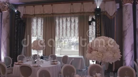 餐厅婚礼装饰及安排四周餐桌上摆满了白色的衣服和瓷器视频的预览图