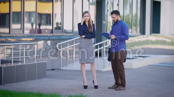 商界人士在外面工作女销售经理站在办公室附近打电话穿着衣服的男人视频的预览图