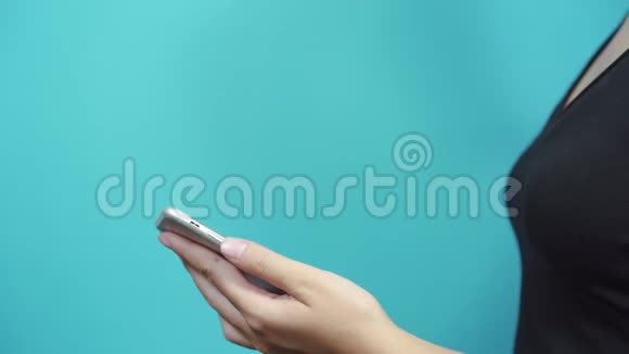 女士在蓝桌背景上使用智能手机女性手滚动网页轻敲触摸屏视频的预览图