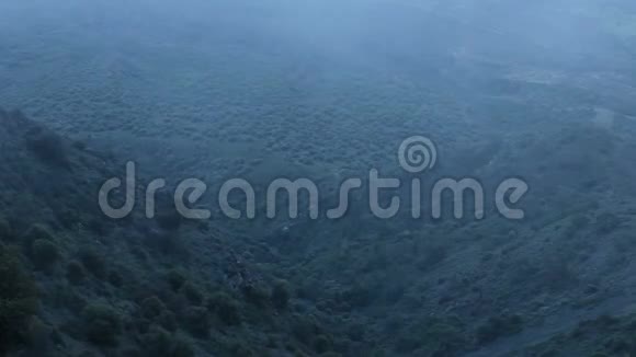 从山顶俯瞰黑暗的雾谷寒冷的夜晚雾蒙蒙的景观自然视频的预览图
