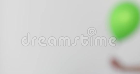女人手握绿色气球白色背景视频的预览图