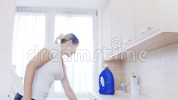 4k片美丽的年轻女子从洗衣机里洗衣服视频的预览图