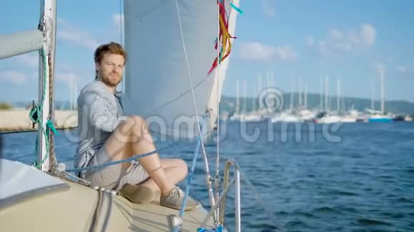 年轻男子坐在游艇上对着镜头微笑视频的预览图