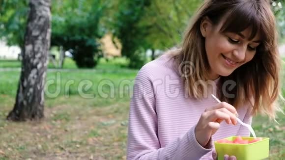 一位年轻漂亮的女士吃西瓜的肖像健康的微笑少女与沙拉和叉子碗体重视频的预览图