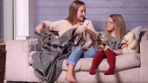 母亲和孩子在家里用毯子取暖视频的预览图
