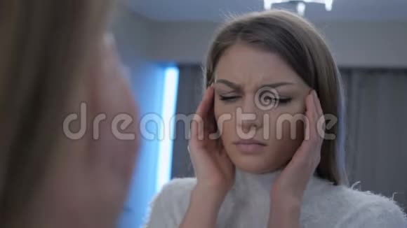 头痛的疲惫女人照镜子视频的预览图