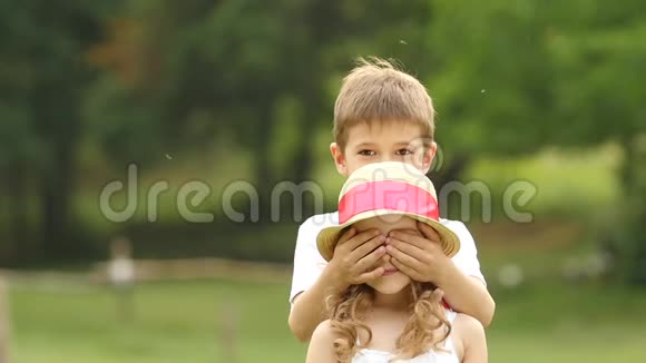 小男孩用自己的手闭上女孩的眼睛慢动作视频的预览图