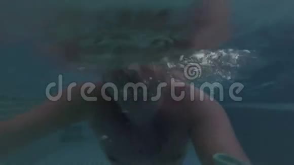 活泼的年轻人在游泳池水下观景晚上游泳操作摄像机视频的预览图