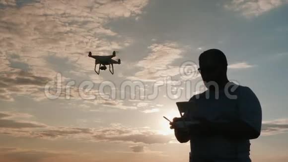 无人驾驶飞机驾驶员在日落时分驾驶直升机剪影视频的预览图
