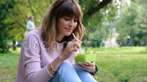 美丽的女孩吃蔬菜沙拉准备和切碎茂盛的绿叶蔬菜健康饮食观念视频的预览图