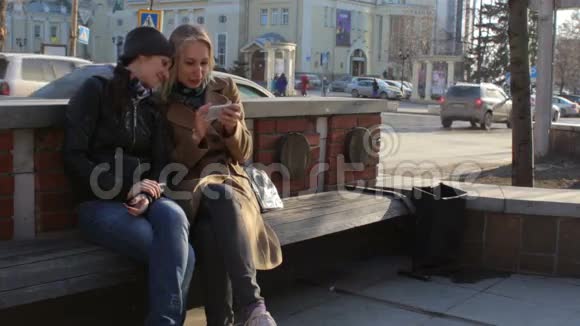 有智能手机的女性朋友在城市街头开心地笑着视频的预览图
