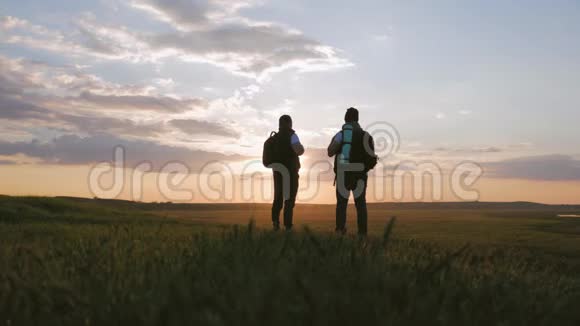 两个人在山顶上的剪影背包和其他齿轮表达能量和幸福二视频的预览图