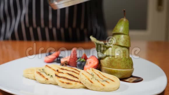 最后的触摸概念餐厅概念用浆果和梨片装饰的白色盘子把厨师的手收起来视频的预览图