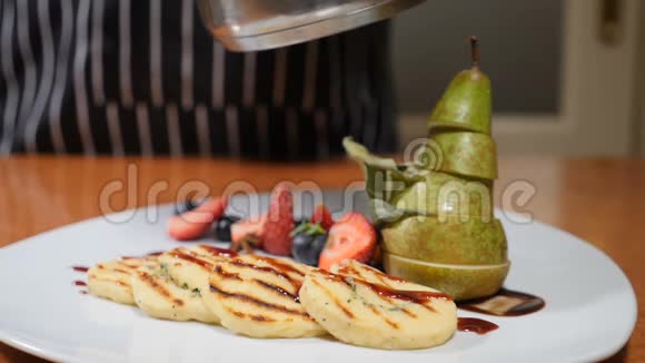 最后的触摸概念餐厅概念用浆果和梨片装饰的白色盘子把厨师的手收起来视频的预览图