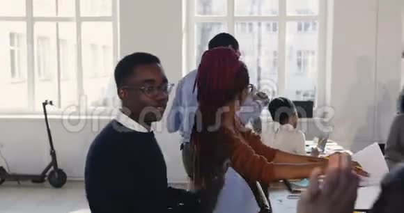 快乐兴奋快乐的黑人办公室经理在多民族同事中跳舞庆祝工作场所的职业成功视频的预览图