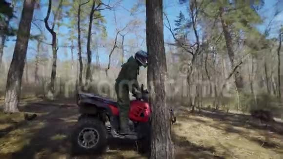 森林里的赛车手那人慢慢地骑着ATV在秋天的脚手架上在森林里最容易训练的视频的预览图